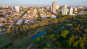 Vista aérea de Indaiatuba, cidade em São Paulo, com áreas urbanas e parque às margens de rio, destacando o bem-estar e negócios no Ranking de Competitividade dos Municípios.