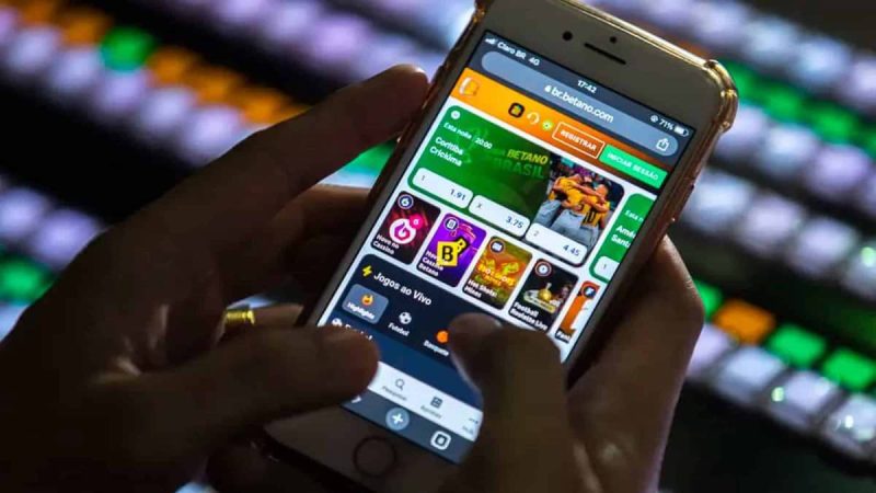 Cubatão aprova projeto para combater vício em bets e prevenir danos: pessoa usando smartphone com aplicativo de apostas em uma tela de jogos