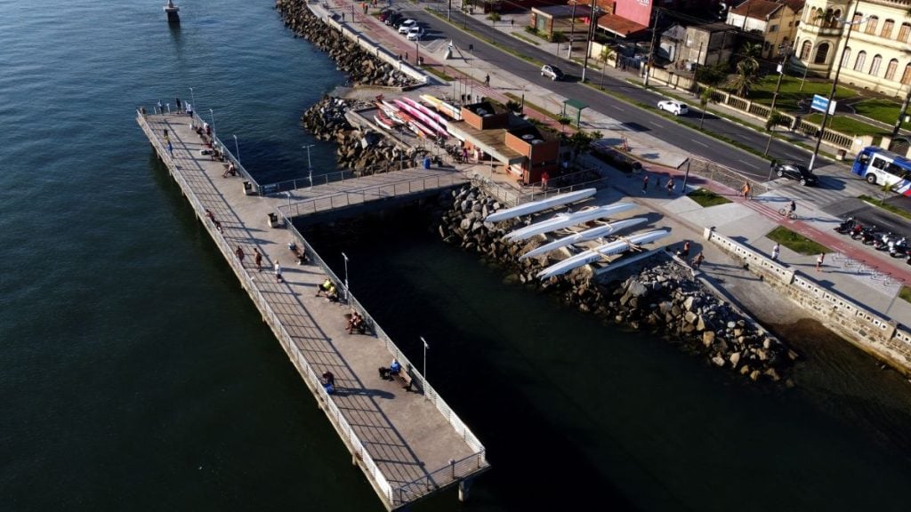 Deck do Pescador de Santos com área de atracação e barcos, molhes de pedras e estrutura à beira do canal, mostrando atividade de Pesca artesanal