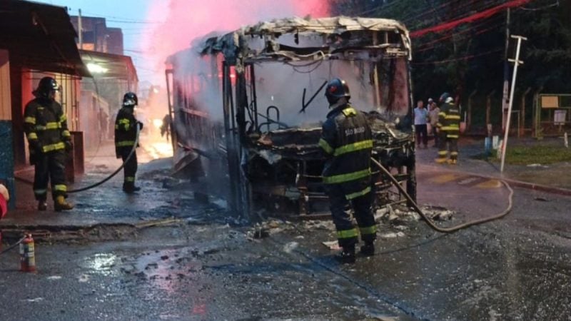 ônibus pega fogo Campinas: equipes do Corpo de Bombeiros combatem incêndio em um ônibus na rua, com chamas e fumaça ao fundo, na cena do resgate