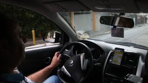 Carro particular na prova da CNH em exame de direção: vista do motorista ao volante de um carro com painel e touchscreen, durante a rotina do teste