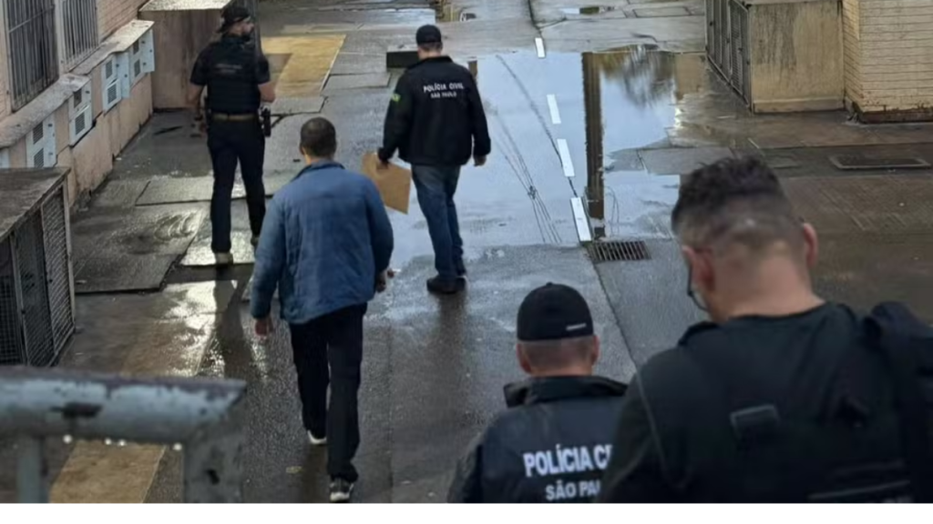 Imagem mostra agentes da Polícia Civil em operação de cumprimento de mandados, caminhando em área externa com viaturas e registro oficial ao fundo, associada a esquema de lavagem de dinheiro