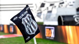 Bandeira da Ponte Preta em estádio, com o escudo do clube ao centro ao lado de estruturas e telões ao fundo. Conteúdo sobre SAF Ponte Preta e transfer bans.