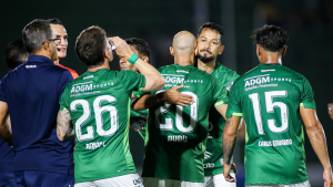 Guarani jogadores fim de contrato: Jogadores do Guarani comemoram em campo, com atletas usando camisas verdes e números nas costas, em imagem de jogo sob luzes do estádio.