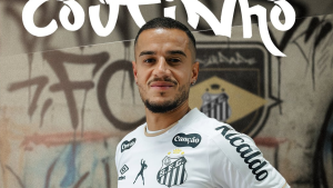 Santos Philippe Coutinho: Jogador do Santos em apresentação com uniforme branco e escudo do clube ao fundo, em imagem de anúncio do novo reforço Philippe Coutinho para a temporada. Santos anuncia Philippe Coutinho como novo reforço para temporada.
