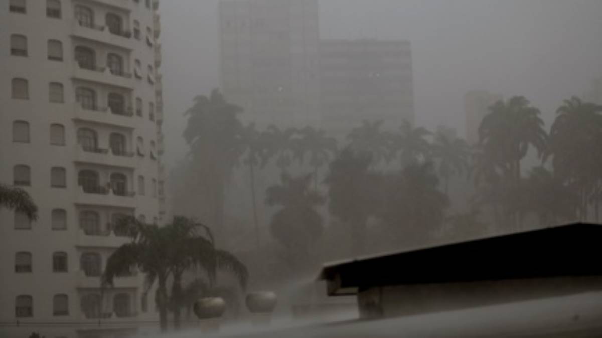 Previsão do tempo em Campinas: imagem mostra chuva e neblina no cenário urbano, com prédios e árvores ao fundo, sugerindo condições meteorológicas instáveis para a quarta-feira.