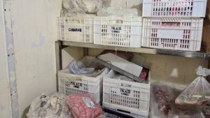 Câmeras e caixas plásticas com carnes em um ambiente de armazenamento, com destaque para carne estragada em açougue apreendida pela polícia em Indaiatuba, com cerca de 350 kg