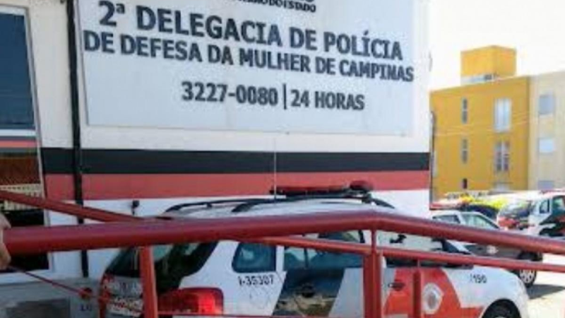 Suspeito de feminicídio em Campinas — cena em frente à 2ª Delegacia de Polícia, com carro de viatura policial e faixa vermelha, sinalizando investigação e prisão
