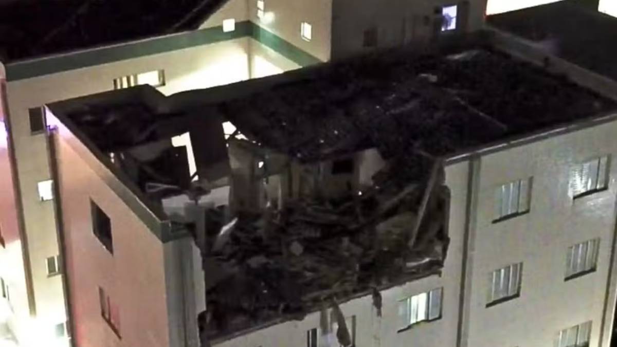 Imagem noturna mostra explosão e danos em um prédio, com destroços visíveis na estrutura e fumaça, em Mongaguá, deixando duas mulheres feridas.