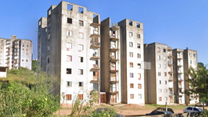 Incêndio em Campinas: prédios residenciais com janelas e varandas ao fundo, cenário urbano após ocorrências no bairro, com vegetação na frente e rua ao nível térreo.