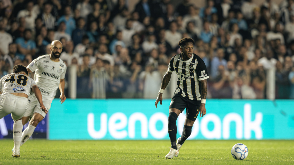 Neymar Atlético: Jogador em campo em partida contra o Santos, em registro do Atlético; Fred em ação durante o jogo, com placa de patrocinador ao fundo e torcida