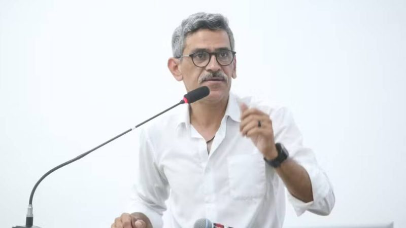 Fabrício Polezi aparece em entrevista, com camisa branca e óculos, falando ao microfone em ambiente de coletiva de imprensa; notícia relata queda de ponte no Rio Piracicaba e internação