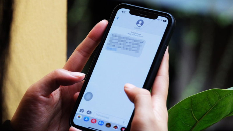 Pessoa segurando um celular com mensagem de contato, cenário que remete a golpes digitais com urgência e manipulação para induzir transferência de dinheiro ou dados.