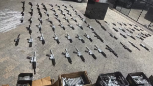 Fábrica clandestina de fuzis em Santa Bárbara: fotografia mostra dezenas de fuzis e peças de armas apreendidas sobre o chão de um ambiente investigado pela polícia