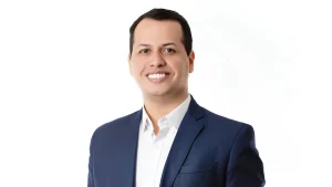 Danilo Morgado preso, candidato a deputado federal pelo PL, aparece em foto falando ao microfone em evento, com expressão séria, enquanto é investigado por suposto financiamento de campanha com dinheiro do PCC.