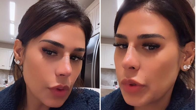 Foto em close da cantora Simone Mendes com cabelo preso, maquiagem marcada com delineador e cílios, brincos pequenos e pele bem iluminada em ambiente interno.