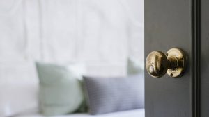 Papo de Síndico em destaque: morador pode mudar a porta do apartamento? Detalhe da maçaneta e da porta de um apartamento em ambiente interno, com foco em manutenção e regras condominiais.