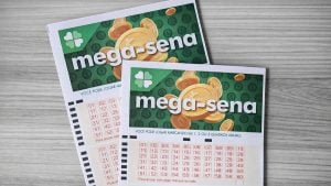Loteria Mega-Sena em cartões de bilhete com números e instruções sobre como jogar, sobre uma superfície cinza, com recortes do jogo e desenhos de moedas.
