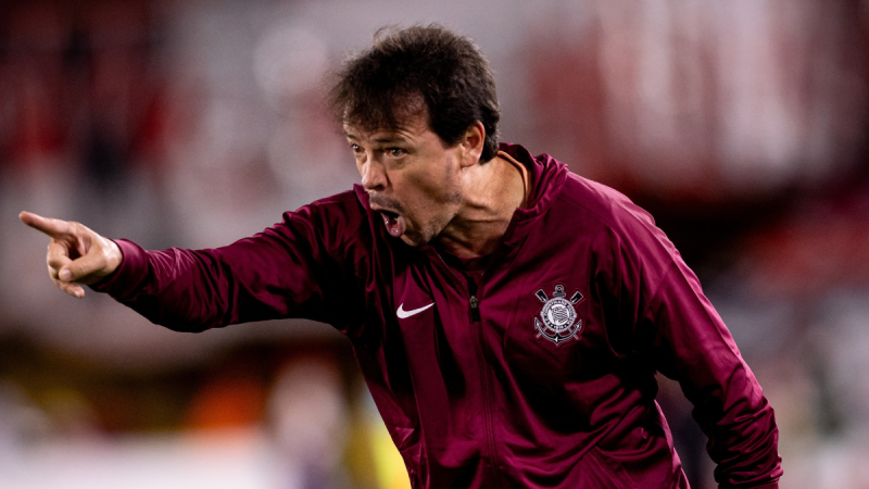 Diniz Corinthians: Treinador Diniz, em foto durante partida, com gesto expressivo à beira do campo, usando uniforme do Corinthians; jogadores querem a permanência do treinador.