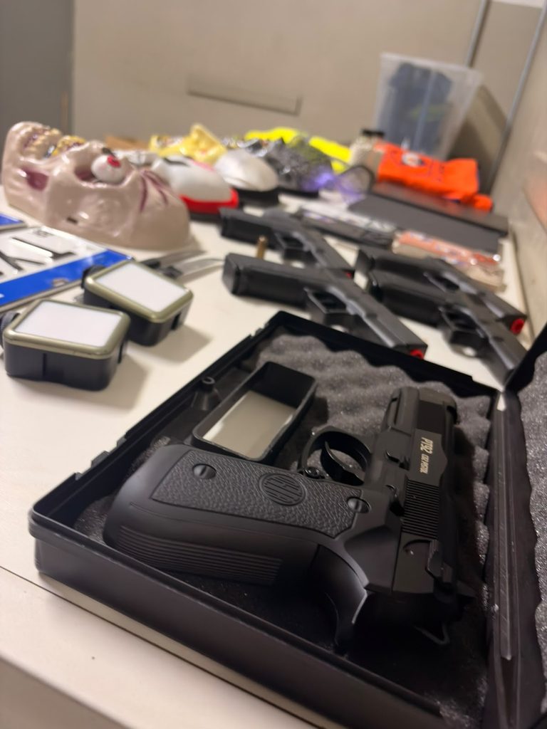 Piracicaba: armas de airsoft apreendidas em caixa, com pistolas e acessórios ao lado de equipamentos de investigação, evidenciando a apreensão após suspeita de ataques na Marcha para Jesus.