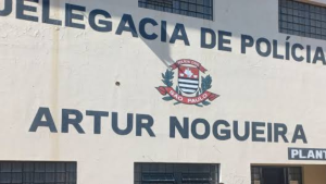 Homens empresariais presos em operação contra lavagem de dinheiro no interior de SP, com fachada de prédio da Polícia Civil de São Paulo ao fundo
