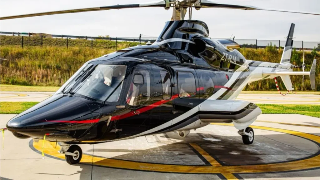 Helicóptero desaparecido em SC em uma pista de aeroporto, com fuselagem preta e branca e detalhes vermelhos, identificado como usado por Rick e Bruno Avelar