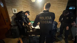 Operação Rota Diplomática: Operação da PF mira esquema de contrabando de eletrônicos via Viracopos: agentes da Polícia Federal realizam abordagem em ambiente interno, com documentos e equipamentos sobre a mesa.