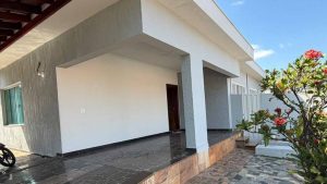 Americana inaugura República para Jovens com capacidade para seis pessoas: entrada de uma residência térrea com área externa, jardim e plantas floridas ao lado