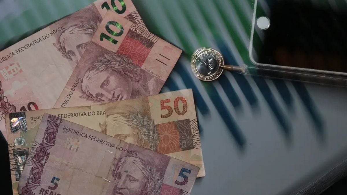 Inflação no Brasil: cédulas de reais sobre um fundo com máquina de contagem de dinheiro, sugerindo impacto no bolso em setembro.