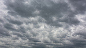 Céu nublado e encoberto, com nuvens densas em tons de cinza e forma dramática, sugerindo mudança de tempo e possível chuva ao fundo