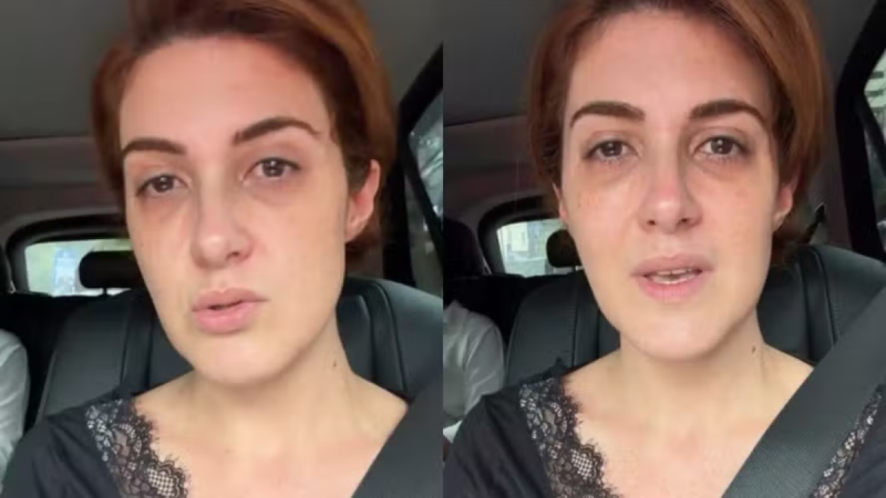 Retrato de Mila Seidl com cabelo castanho curto dirigindo, usando top de renda e cinto de segurança no banco do motorista do carro, em ambiente interno.