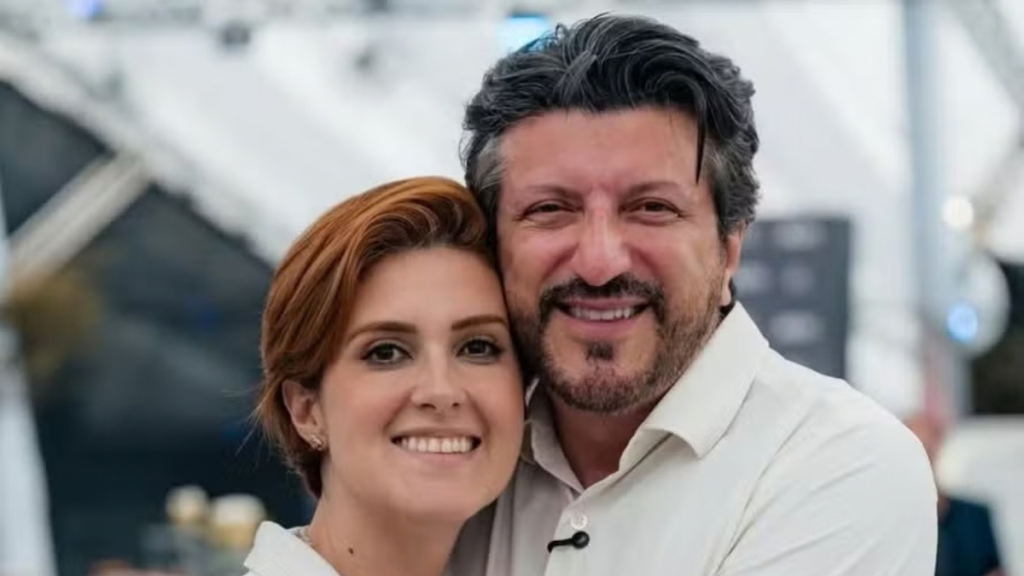 Lito e Mila em ambiente corporativo, com mulher e homem de cabelo escuro e barba, abraçados e olhando para a câmera, transmitindo alegria e confiança