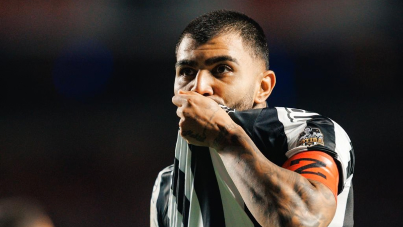 Gabigol, jogador do Santos, comemora gol beijando o escudo do clube.