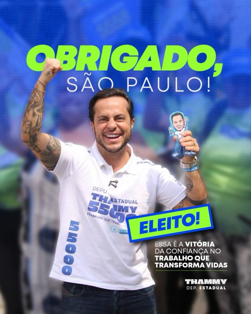 Thammy Miranda comemora a eleição para deputado estadual em São Paulo em 2026, segurando um boneco e levantando o braço em sinal de vitória.