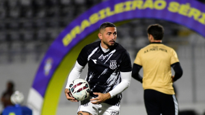 Danilo Barcelos, lateral da Ponte Preta, segura uma bola durante aquecimento no campo.