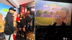 Cena em evento infantil com um adulto usando chapéu e moletom, ao lado de uma mulher e uma criança segurando um brinquedo, em frente a um telão com personagem e cenário de cinema.
