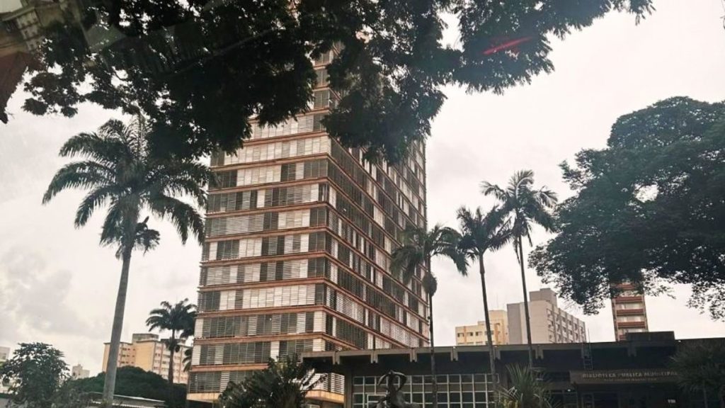 Fachada do Palácio dos Jequitibás, sede da Prefeitura Municipal de Campinas, com edifícios, árvores e palmeiras ao redor.