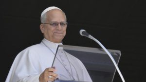 Papa Leão XIV em foto oficial no Vaticano, em frente a um púlpito e microfone, durante discurso ou cerimônia. Imagem registrada para matéria sobre saúde e cirurgia.