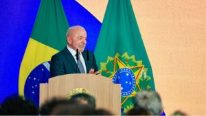Presidente Lula discursa em púlpito diante das bandeiras do Brasil durante evento oficial.