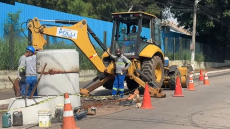 Equipes trabalham em obra de manutenção de rede com retroescavadeira e caixas em rua, em ação para enfrentar a falta de água em Sumaré
