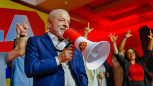 Lula aparece sorrindo e com megafone durante discurso.