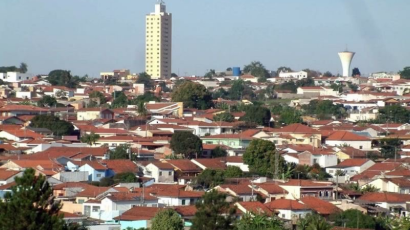 Vista aérea de Mogi Mirim com prédios altos, ruas movimentadas e área com árvores e jardins em primeiro plano, em um dia claro