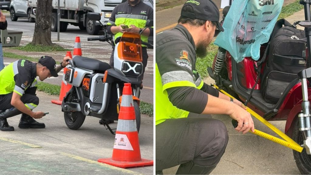 Técnicos de segurança realizam testes e verificação em uma motocicleta, ajustando ou inspecionando componentes próximos à roda e ao painel, em ambiente externo com cones de sinalização e fita de demarcação.