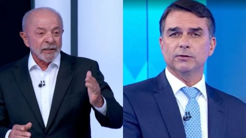 Composição com Luiz Inácio Lula da Silva à esquerda gesticulando de fato escuro e Flávio Bolsonaro à direita de fato e gravata azul durante debate na TV Globo.