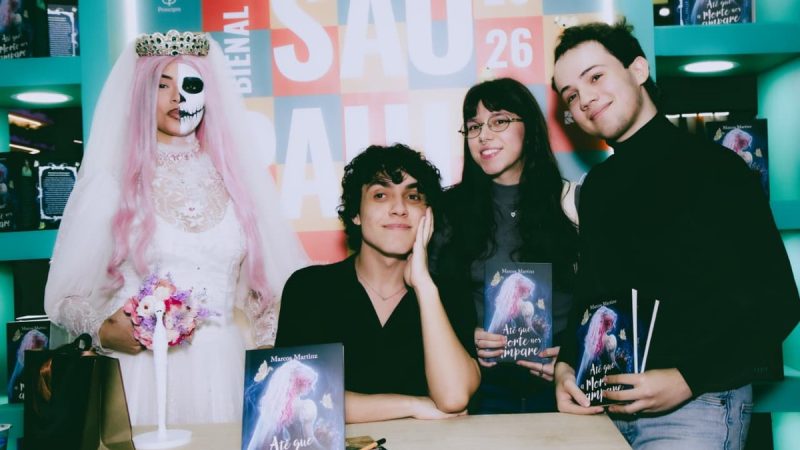 Marcos Martinz posa com leitores e personagem caracterizada durante evento de lançamento de seu livro na Bienal de São Paulo. Foto: Divulgação