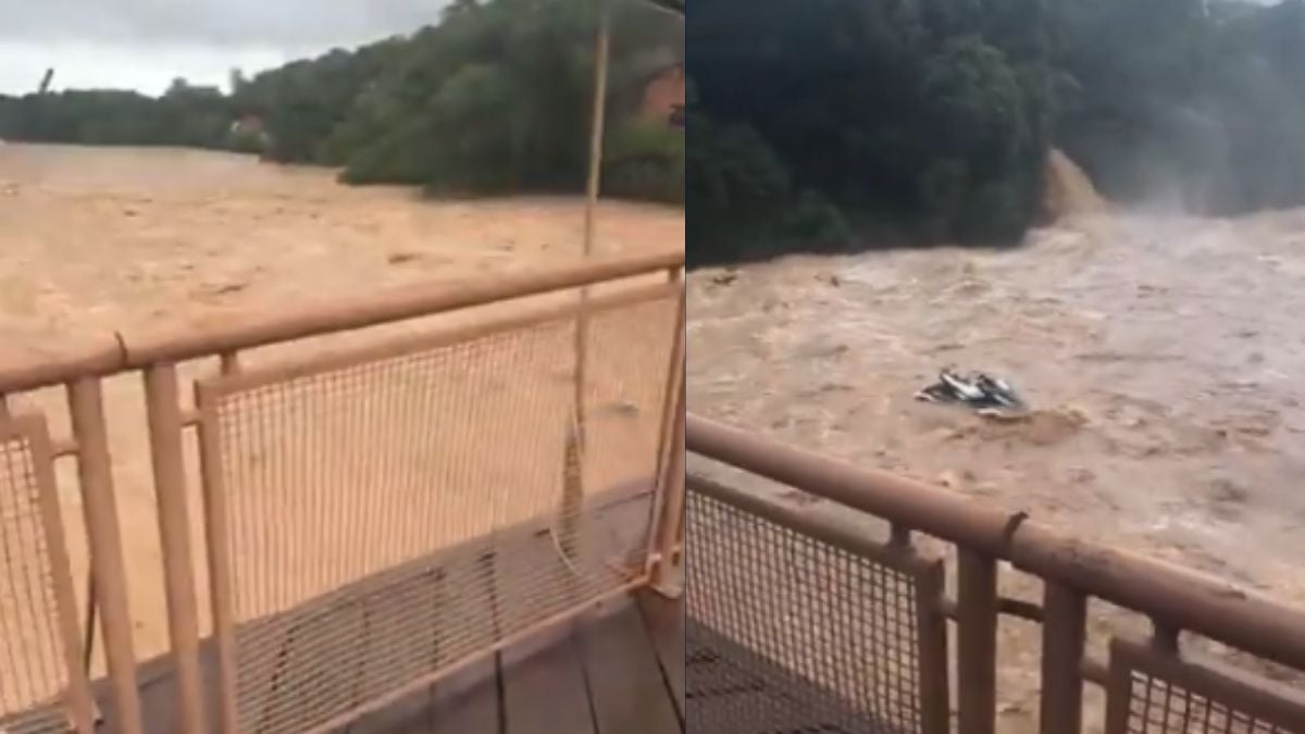 Rio Piracicaba visto de uma estrutura com corrimão de metal, mostrando o leito alagado com água barrenta e vegetação ao fundo, em meio a forte corrente.