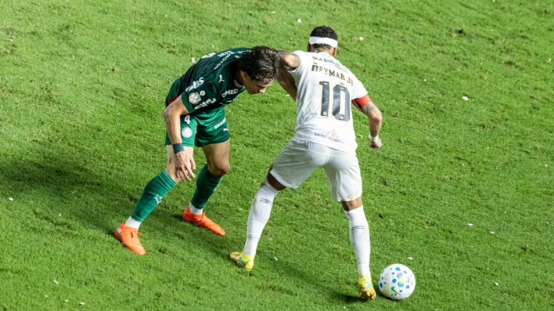 Neymar disputa bola com jogador do Palmeiras durante clássico na Vila Belmiro.