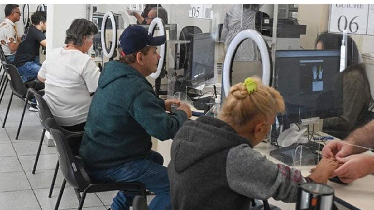Equipe de técnicos atendendo em laboratório com equipamentos de medição e assistência ao cliente, em uma sala de atendimento com balcões e monitores