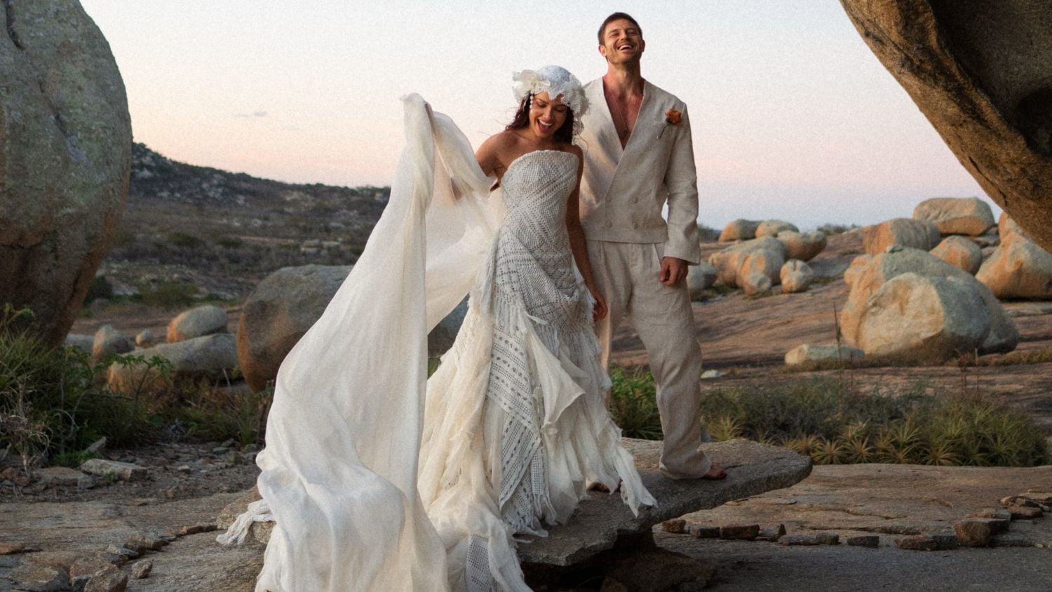 Juliette e Kaique Cerveny em casamento intimista ao ar livre, com a noiva de vestido branco e véu e o noivo de terno claro, em Lajedo de Pai Mateus na Paraíba