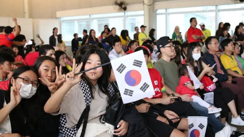 Plateia de jovens com bandeias da Coreia
